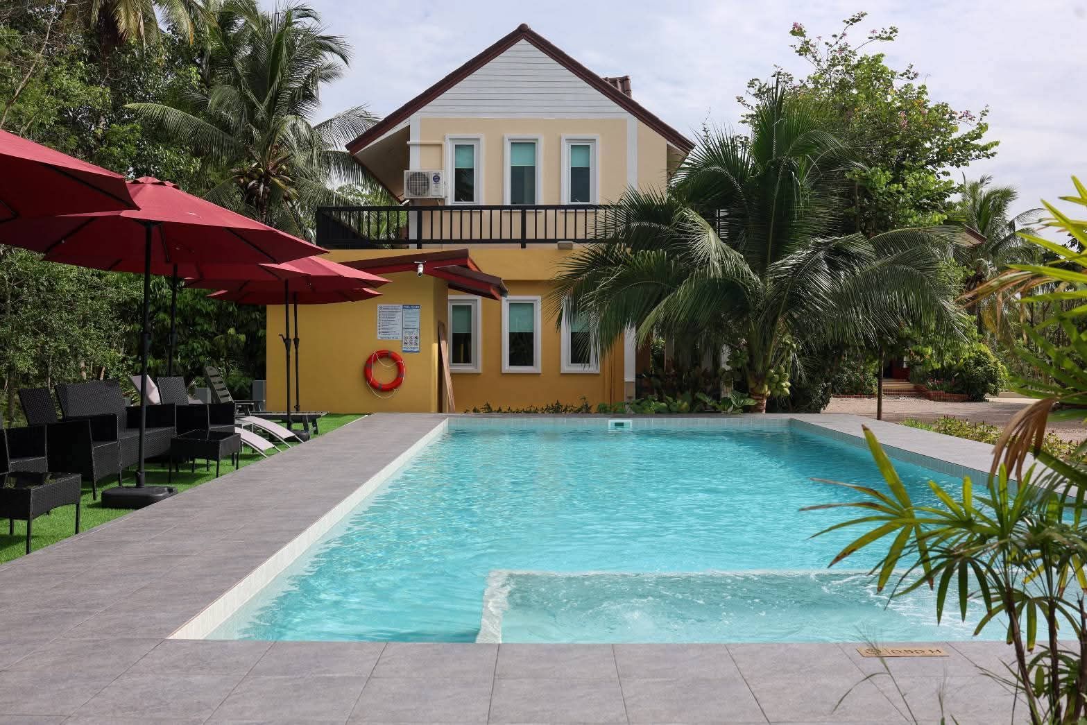 Swimming pool in front of the yellow guest house at Baan Sara Boutique Resort